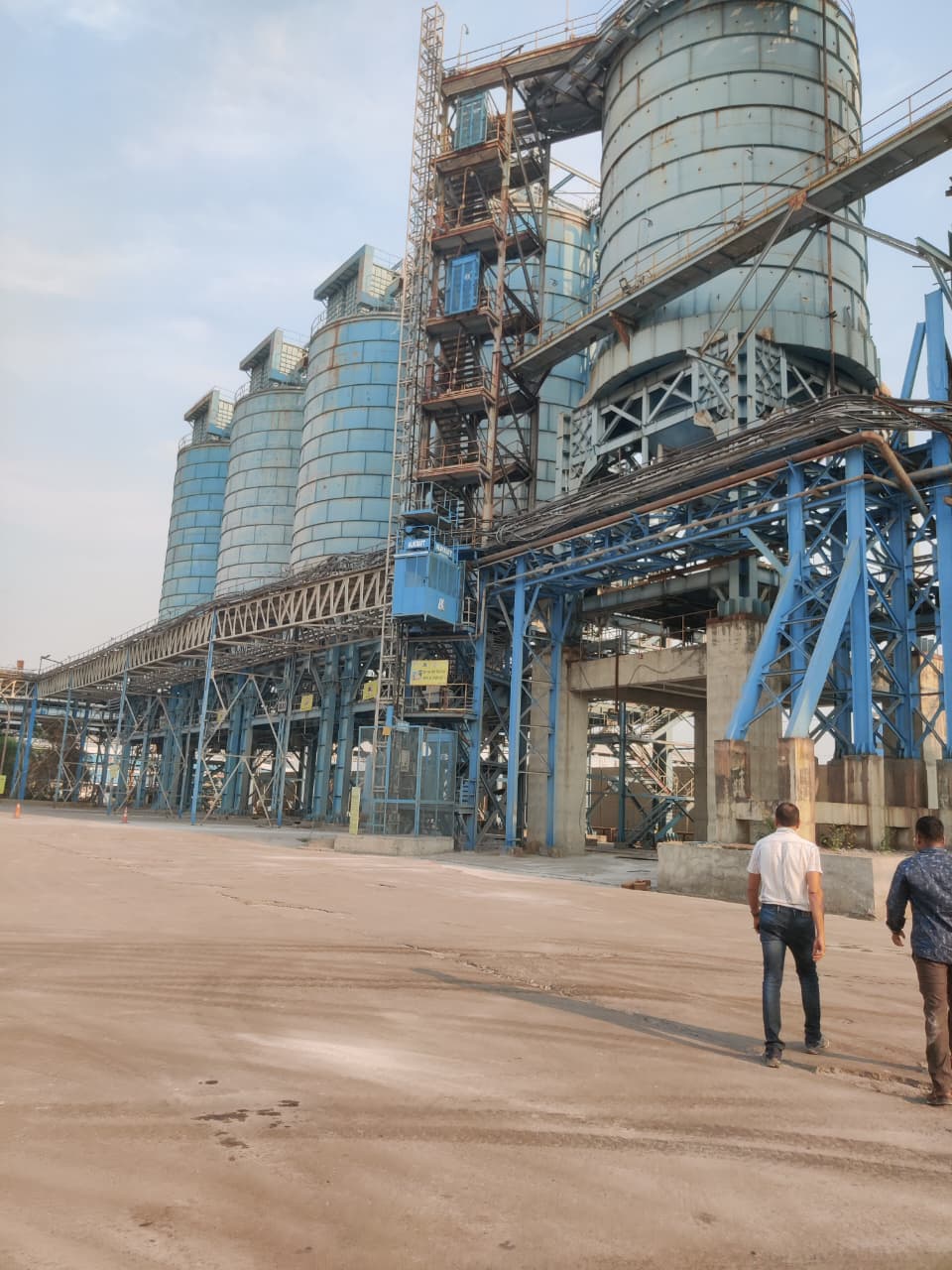 Row of storage silos with material-handling gantry at the plant
